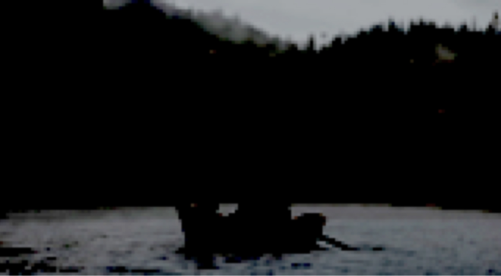 Picture of fishermen in a boat on a lake, very degraded