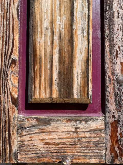 Door detail, old pine wood and purple paint