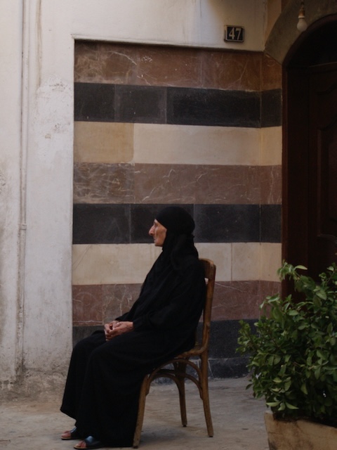 Old lady sitting stiff on a chair